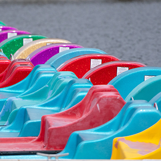 a row of colorful paddle boats docked.