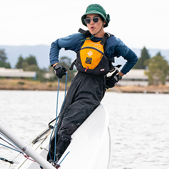 A man manuvering his boat while it is on its side.