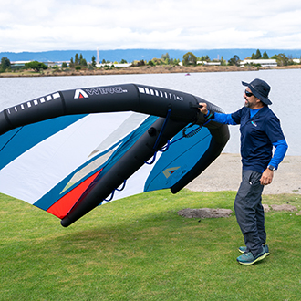 An instructor showing the basics of wingfoiling with a sail
