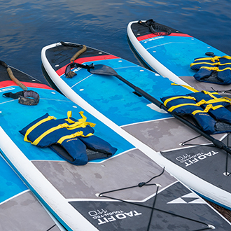 Three standup paddle boards lined up ready to be launched.