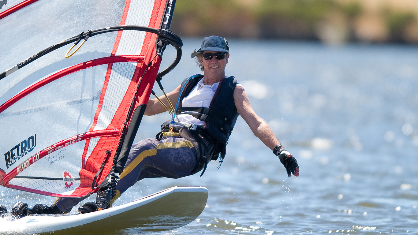 A man windsurfering on shoreline lake