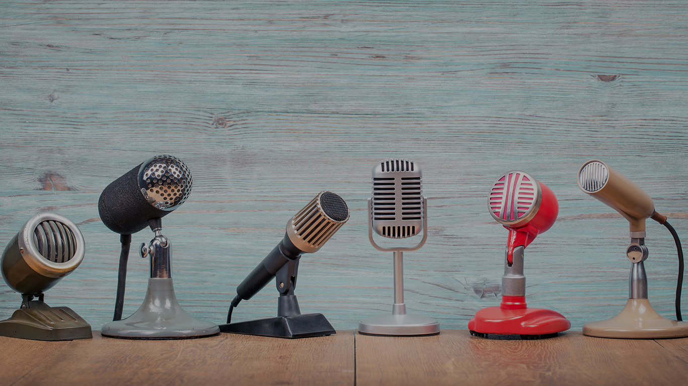 Six mircophones lined up against a wall.