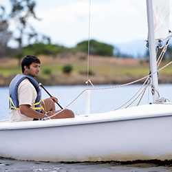 A man sitting in a sailboat.