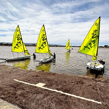 Several boats on the beach getting launched.