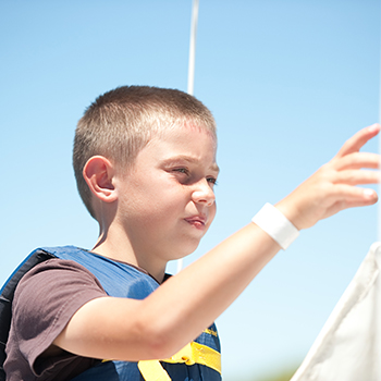 A boy learing how to sail.