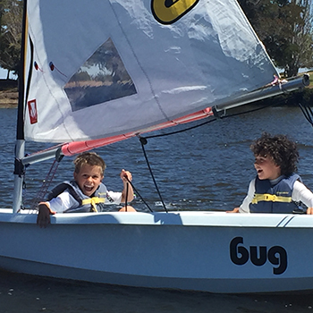 Two boy smiling in a sailboat