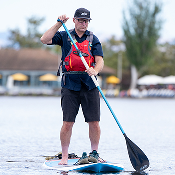 A man on the lake paddle boarding
