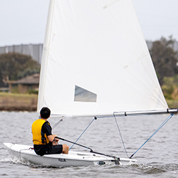 A boy in a boat saiing fast
