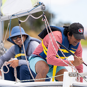 Two mean in a sailboat having fun.