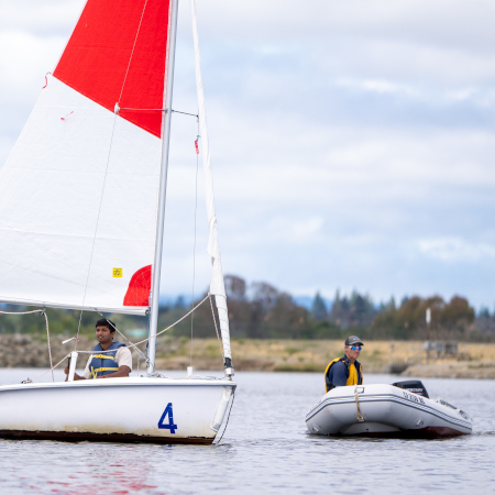 Coaching a sailboat from a powerboat.