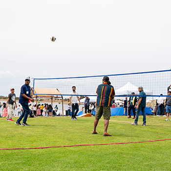 People playing volleyball at shoreline lake