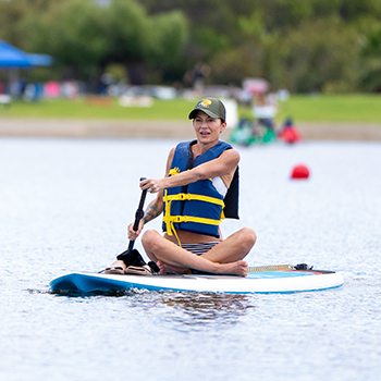 A woamn sitting on her paddle board